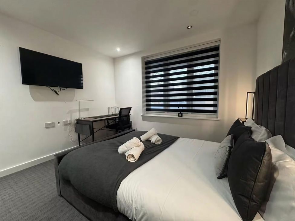 A bedroom with a bed and desk at Flat 1 Hilltop Court in Uxbridge