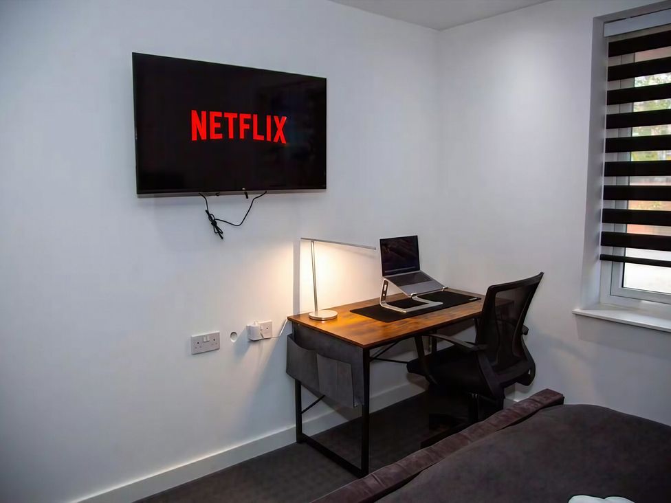 A bedroom with a desk and laptop at Flat 1 Hilltop Court in Uxbridge