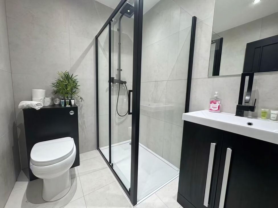 A bathroom with a shower, toilet, and sink at Flat 1 Hilltop Court in Uxbridge