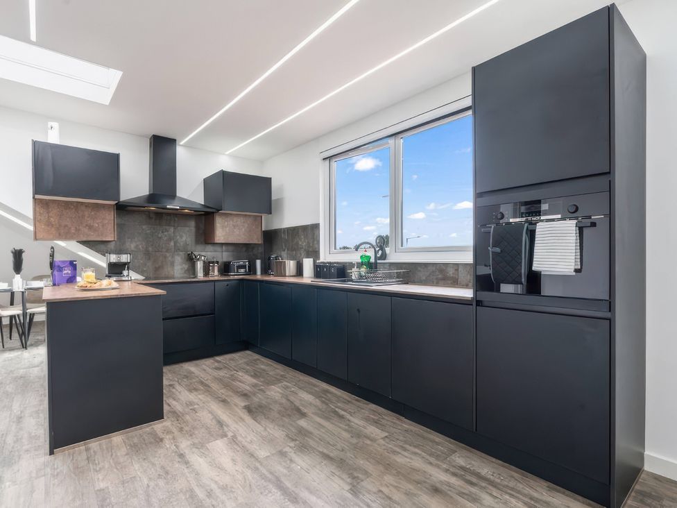 A kitchen with cabinets and appliances at Flat 6, Hilltop Court in Uxbridge