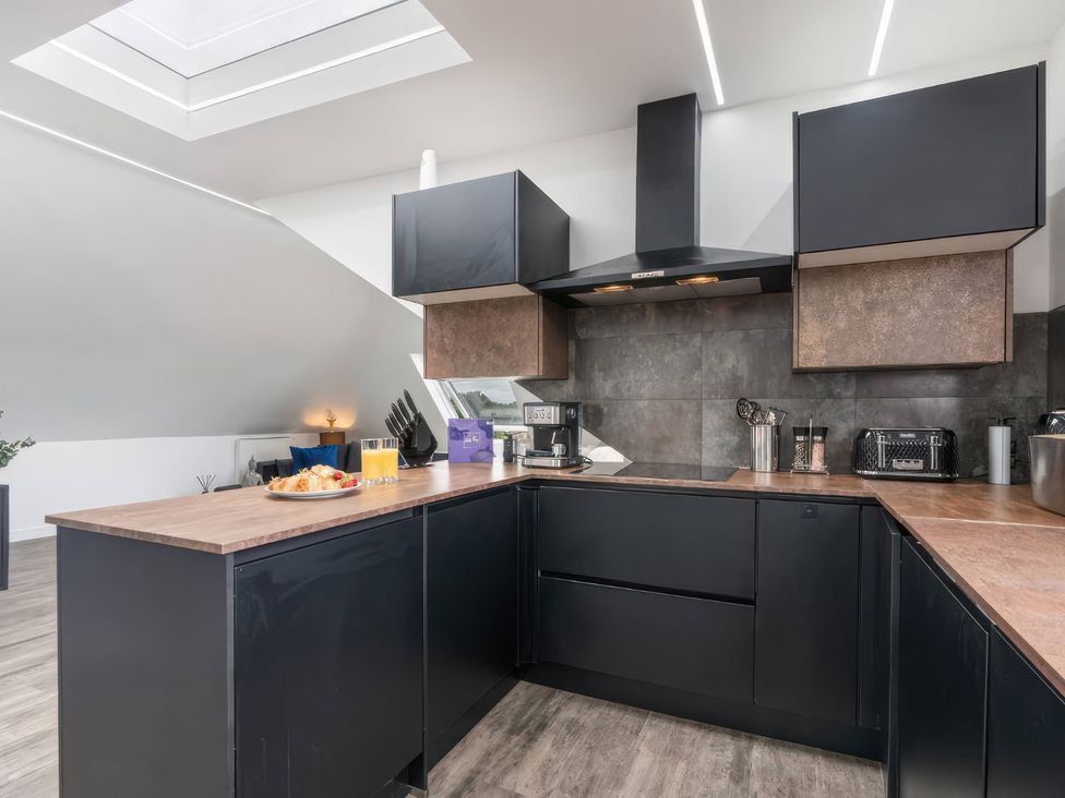 A kitchen with black cabinets and a countertop at Flat 6, Hilltop Court in Uxbridge