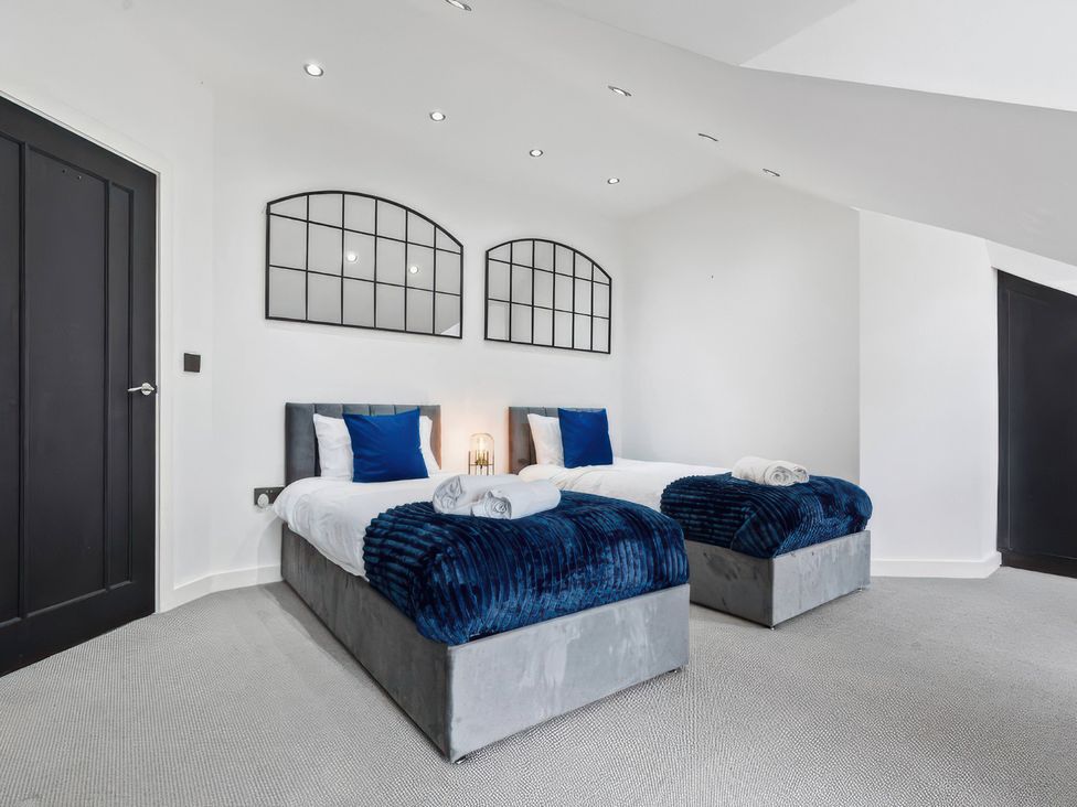 A bedroom with two single beds and wall art at Flat 6, Hilltop Court in Uxbridge