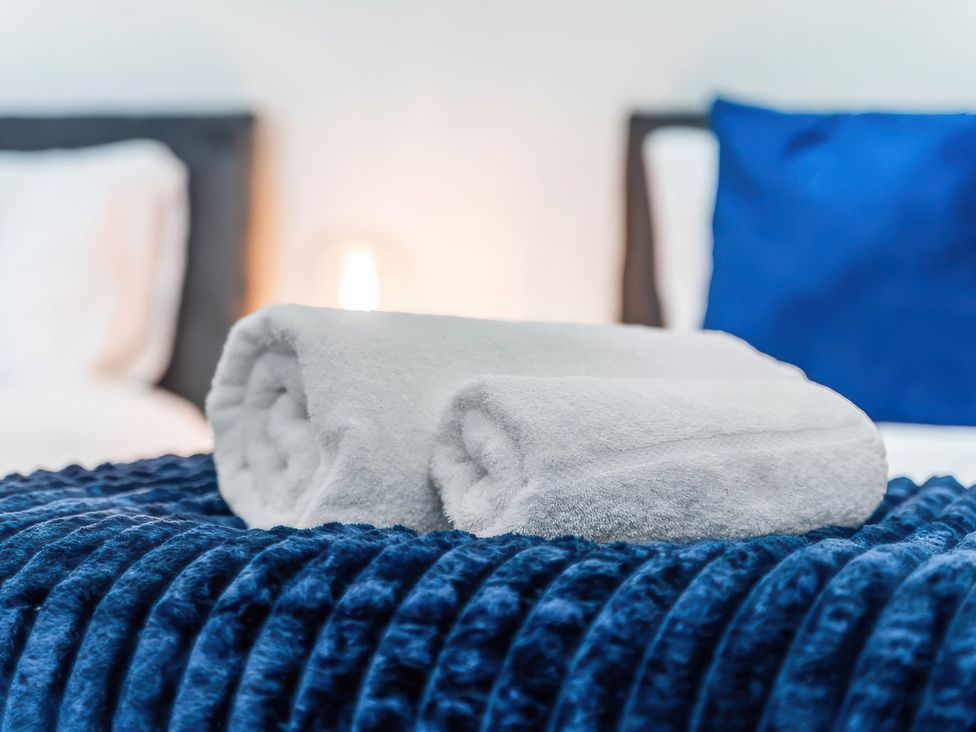 Towels rolled on a blue bedspread at Flat 6, Hilltop Court Uxbridge