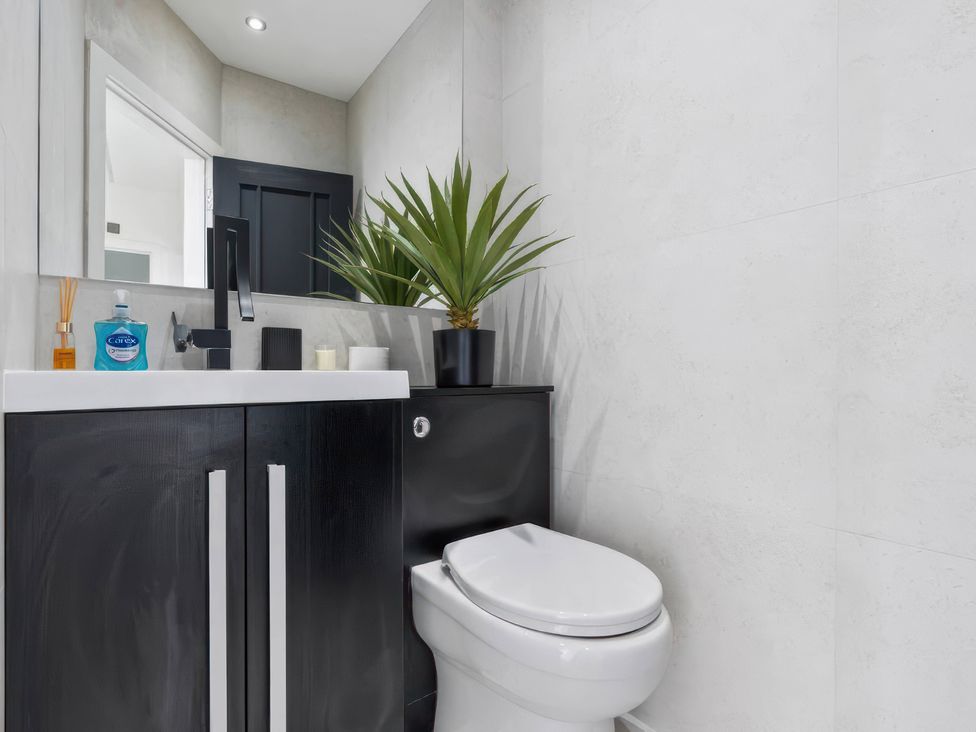 A bathroom with a sink, a toilet, and a plant at Flat 6, Hilltop Court Uxbridge