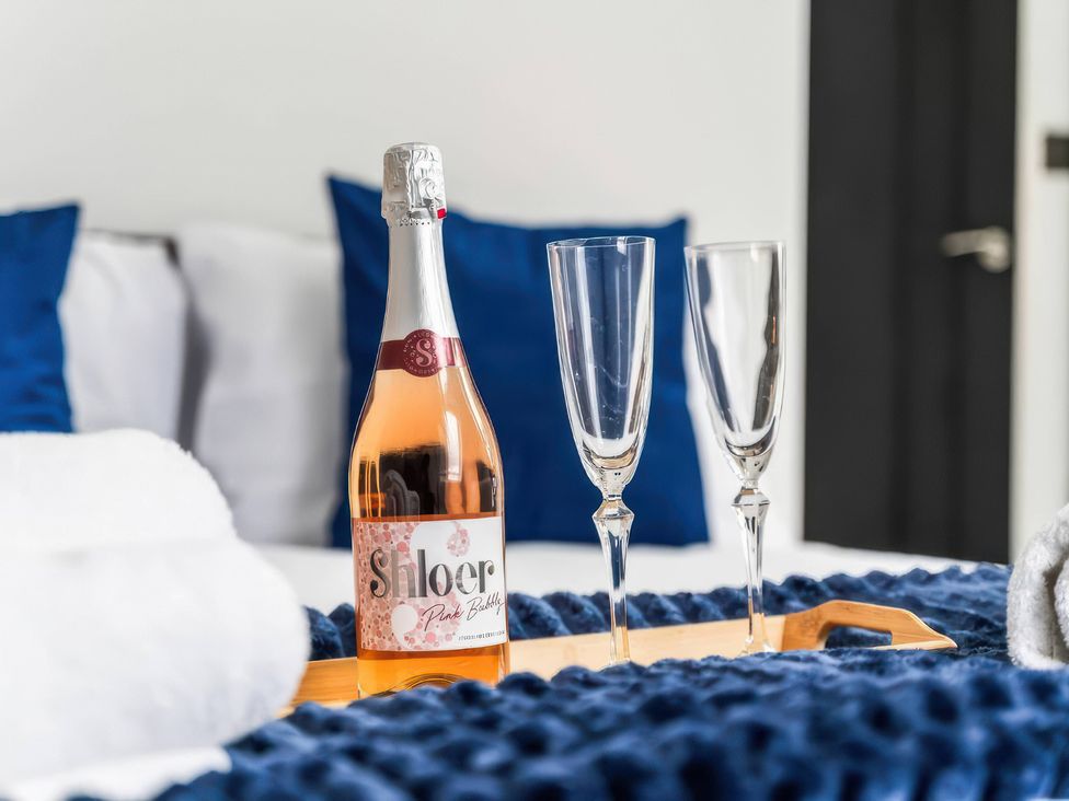 A bottle of Shloer and champagne flutes on a tray in a bedroom at Flat 6, Hilltop Court Uxbridge
