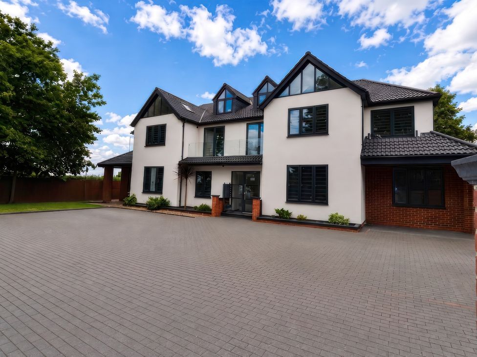 A house with a driveway and garden at Flat 6, Hilltop Court in Uxbridge