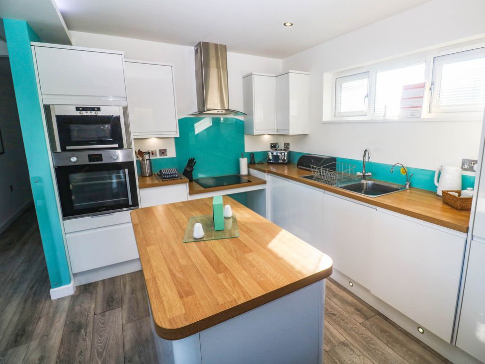 A kitchen with cabinets, oven, sink, and countertop at 74 Porthmeor in Redruth