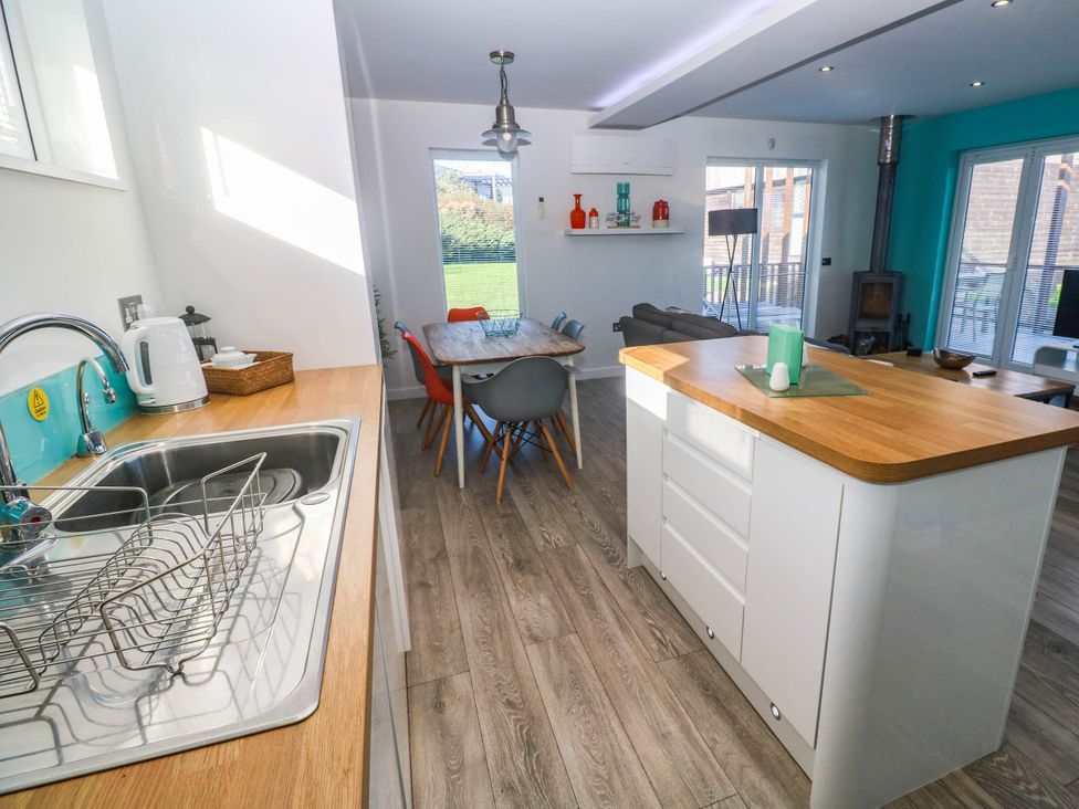 A kitchen with a dining table and living area at 74 Porthmeor in Redruth