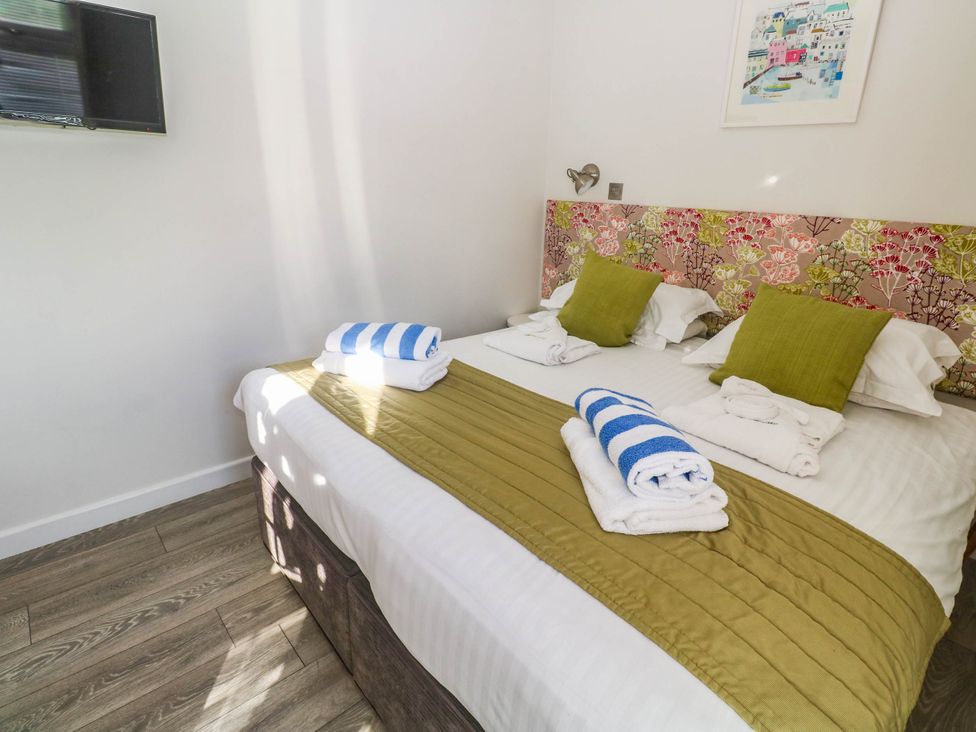 A bedroom with a bed and towels arranged at 74 Porthmeor Redruth