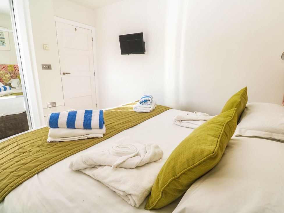 A bedroom with towels and a television at 74 Porthmeor in Redruth
