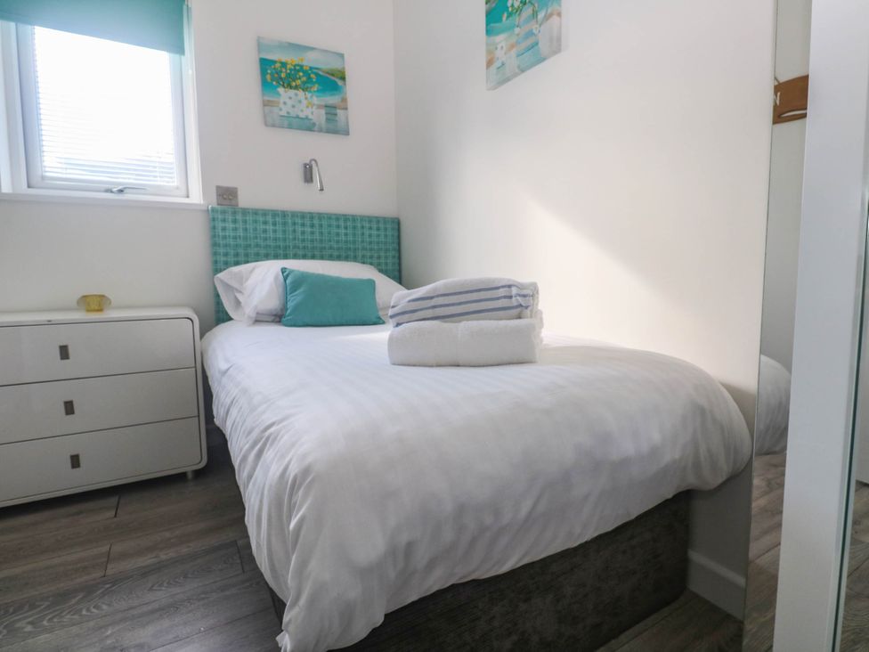 A bedroom with a bed and chest of drawers at 74 Porthmeor in Redruth