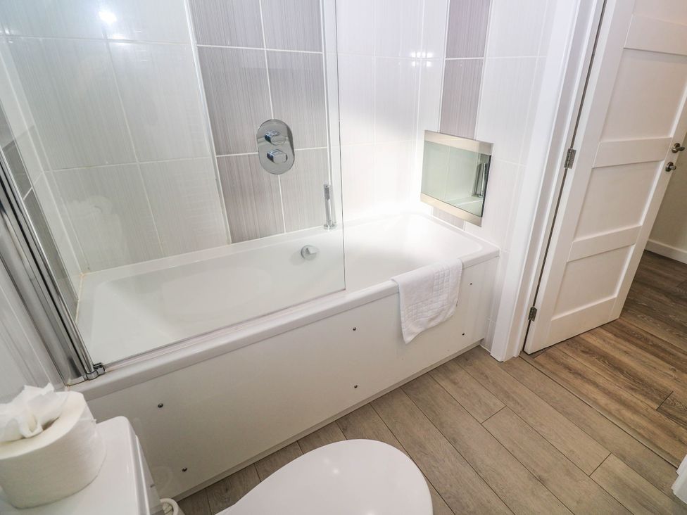 A bathroom with a shower over a bathtub at 74 Porthmeor in Redruth