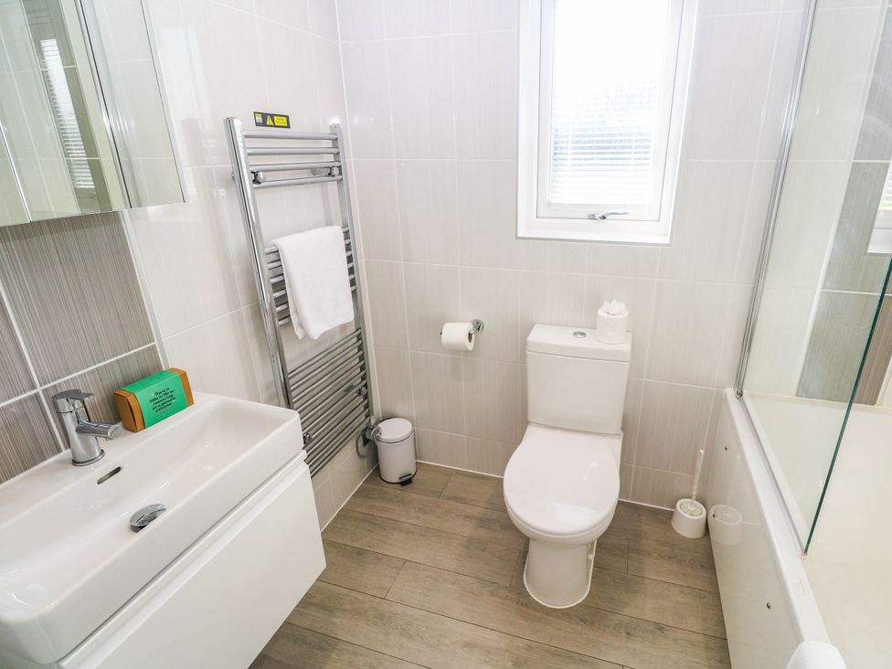 A bathroom with a sink, toilet, and towel rack at 74 Porthmeor in Redruth