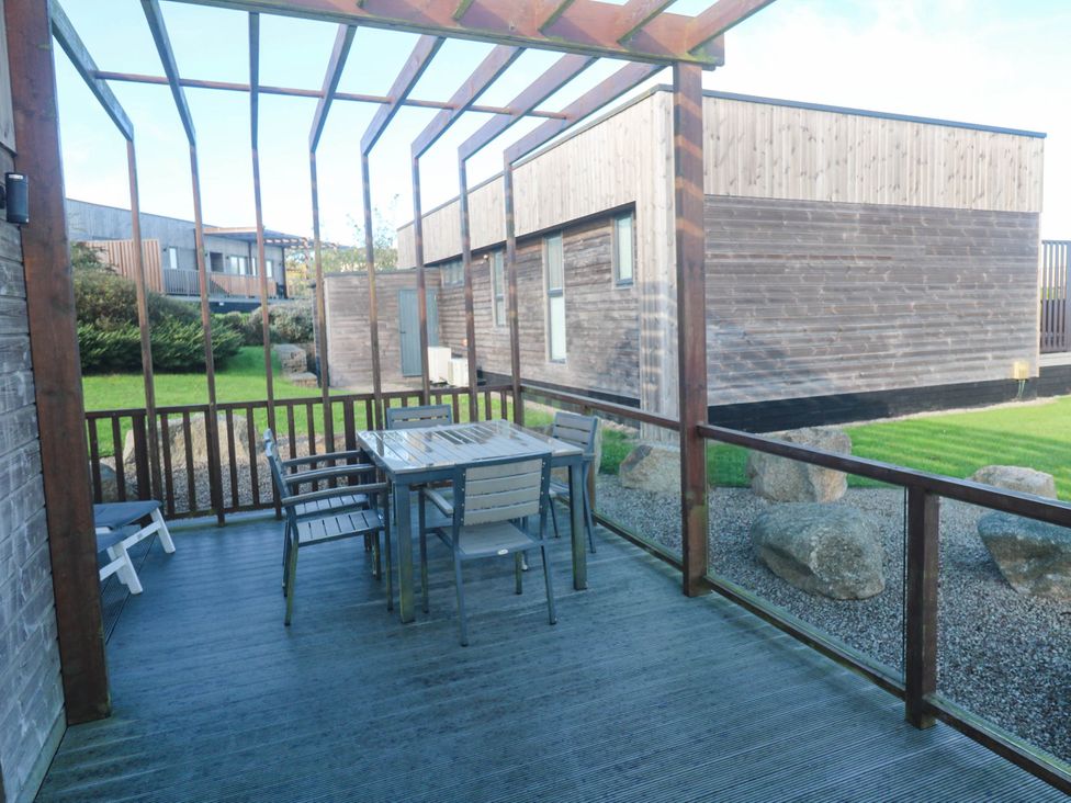 An outdoor patio with a table and chairs at 74 Porthmeor in Redruth