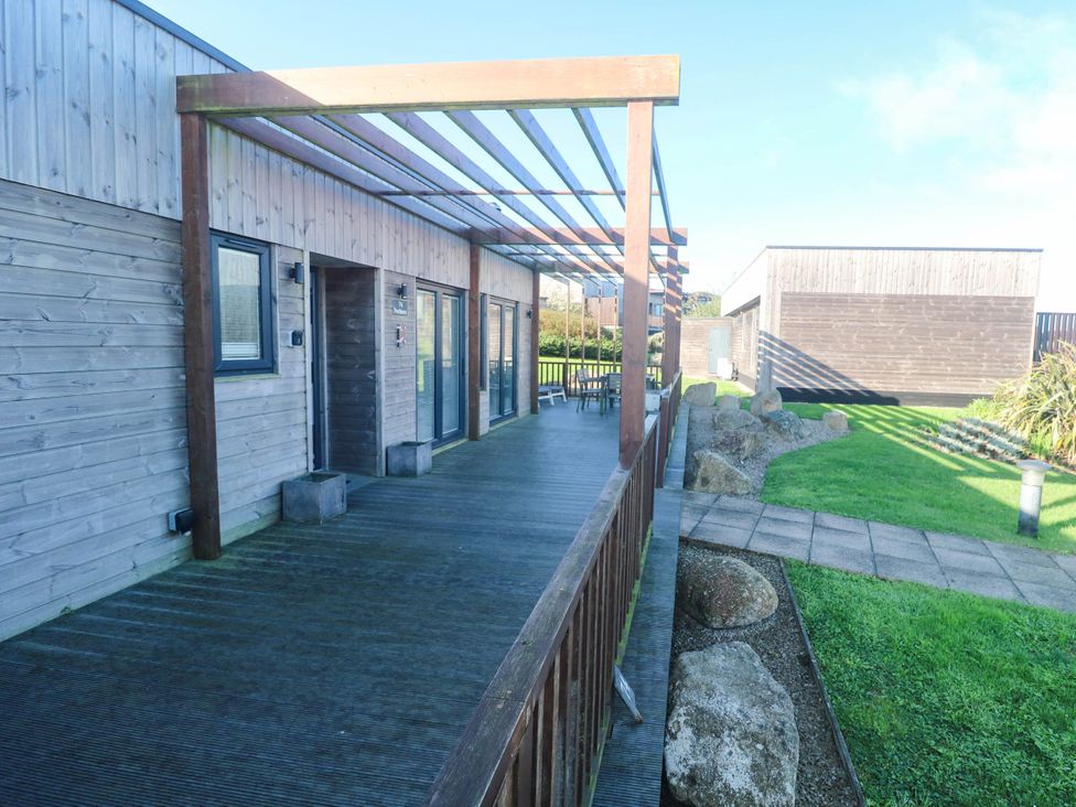 An outdoor area with a wooden deck and furniture at 74 Porthmeor in Redruth