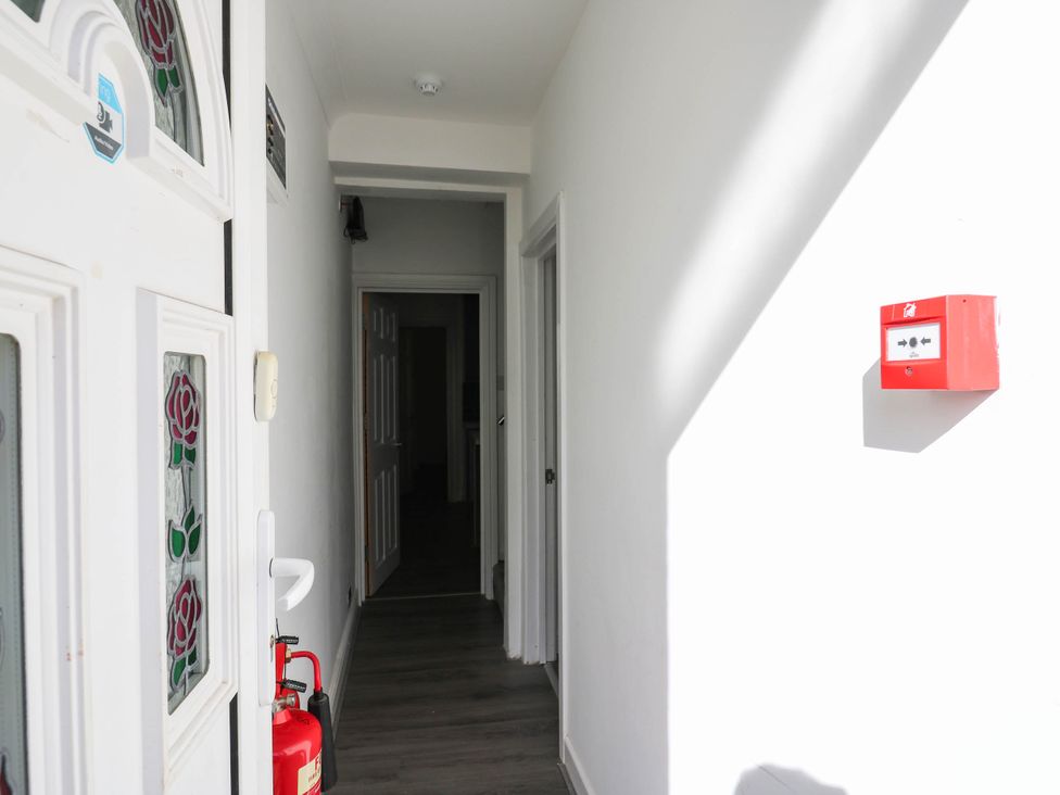 A hallway with a front door and a fire extinguisher at Gillingham House in Gillingham, Kent