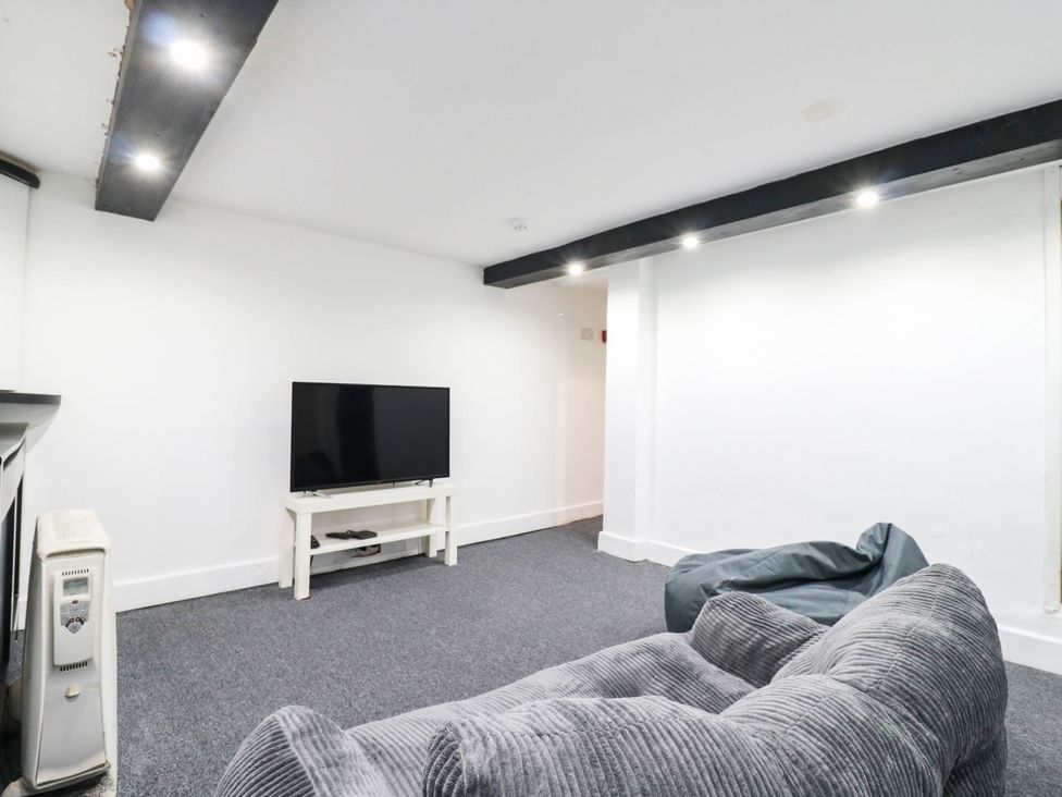 A living room with a television and sofa at Gillingham House in Gillingham, Kent