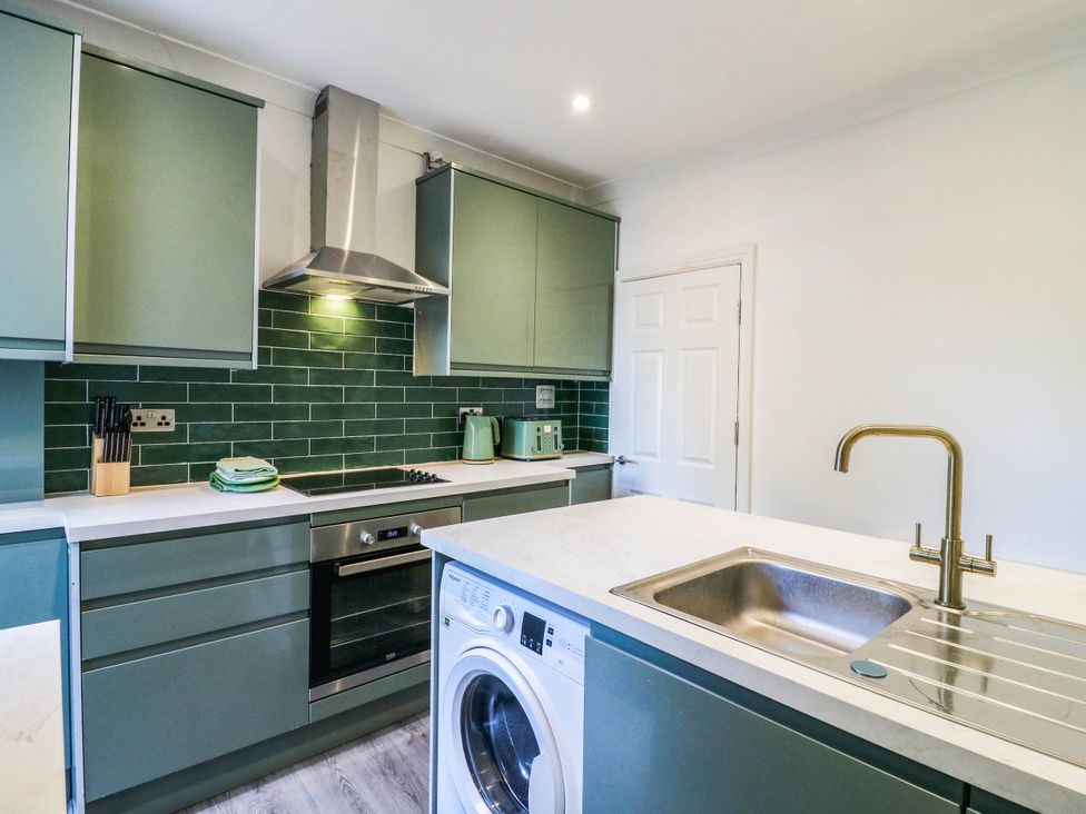 A kitchen with cabinets and appliances at Gillingham House in Gillingham, Kent