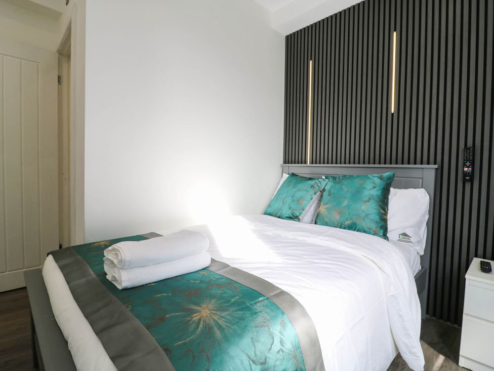 A bedroom with a bed and towels at Gillingham House in Gillingham, Kent