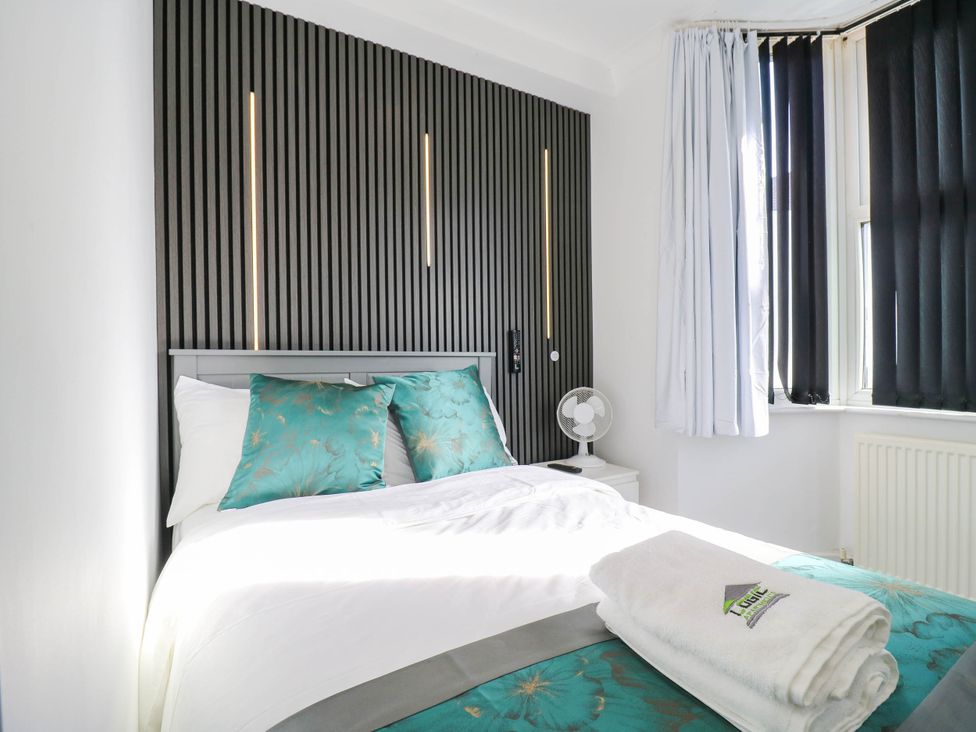 A bedroom with a bed and a fan at Gillingham House in Gillingham, Kent