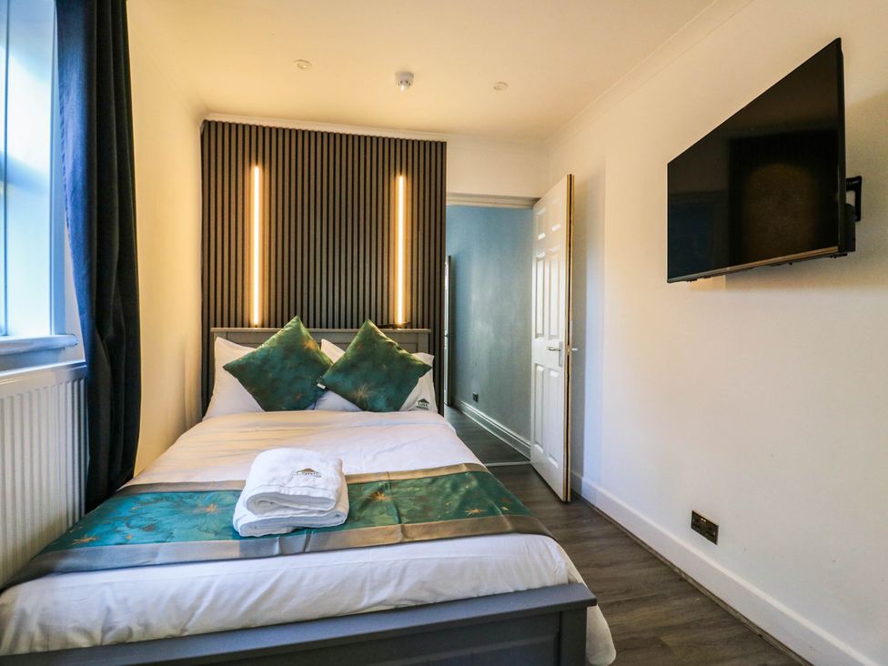 A bedroom with a bed and television at Gillingham House in Gillingham, Kent