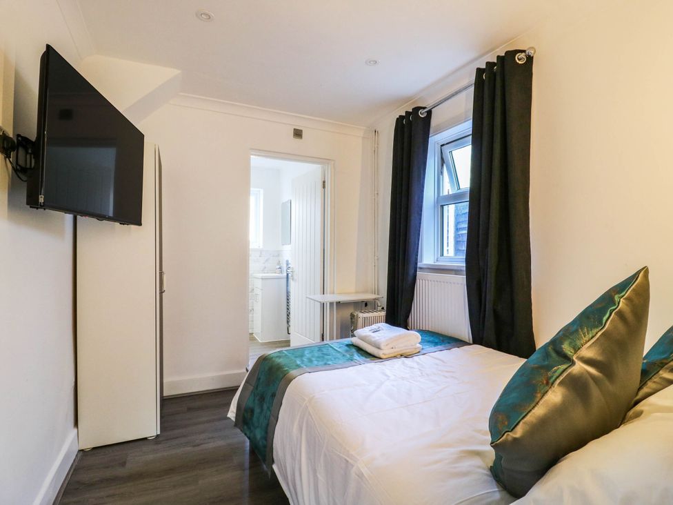 A bedroom with a bed and television at Gillingham House in Gillingham, Kent