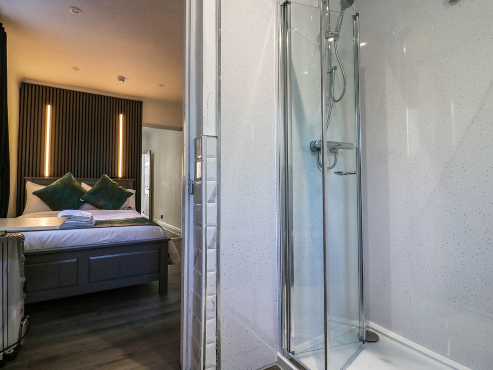 A bedroom with a shower and towels at Gillingham House in Gillingham, Kent
