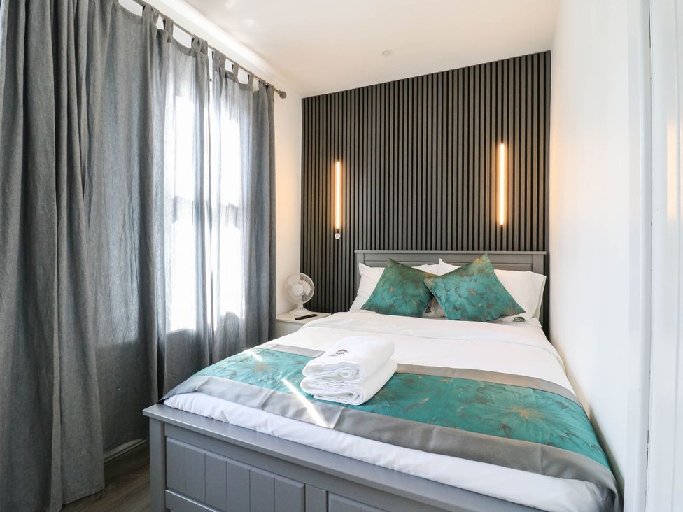 A bedroom with a bed and curtains at Gillingham House in Gillingham, Kent