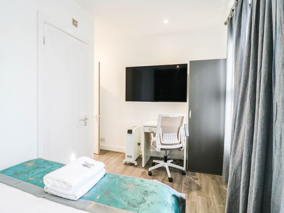 A bedroom with a desk and television at Gillingham House in Gillingham, Kent