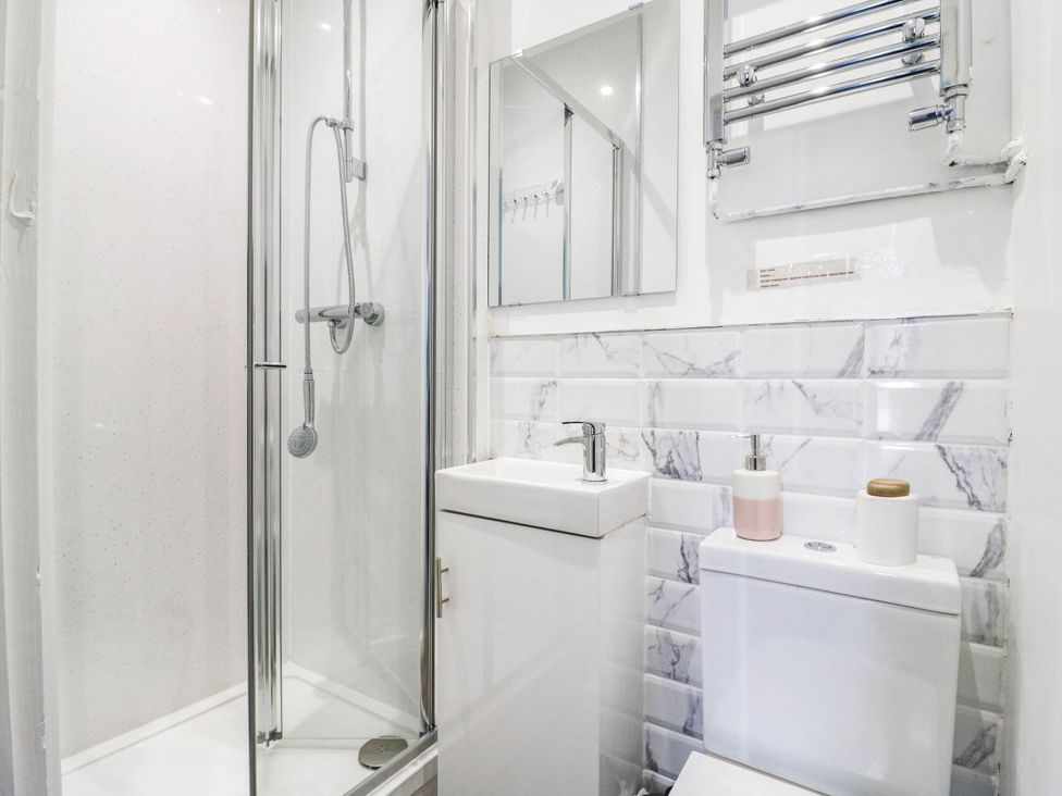 A bathroom with a shower, sink, and toilet at Gillingham House in Gillingham, Kent