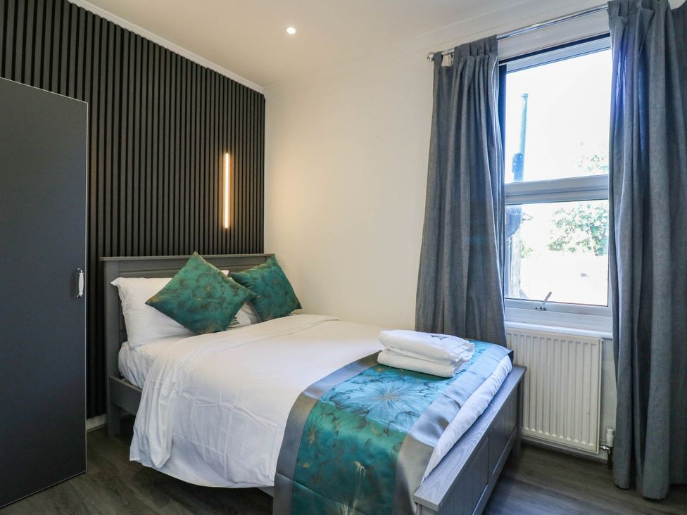 A bedroom with a bed and wardrobe at Gillingham House, Gillingham, Kent