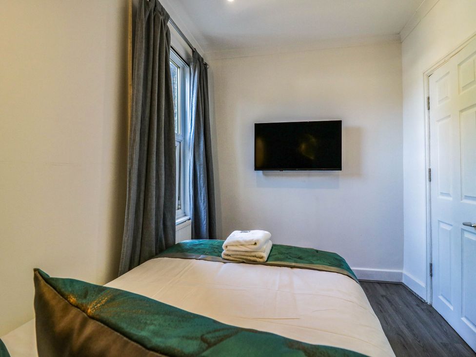 A bedroom with a bed and television at Gillingham House in Gillingham, Kent