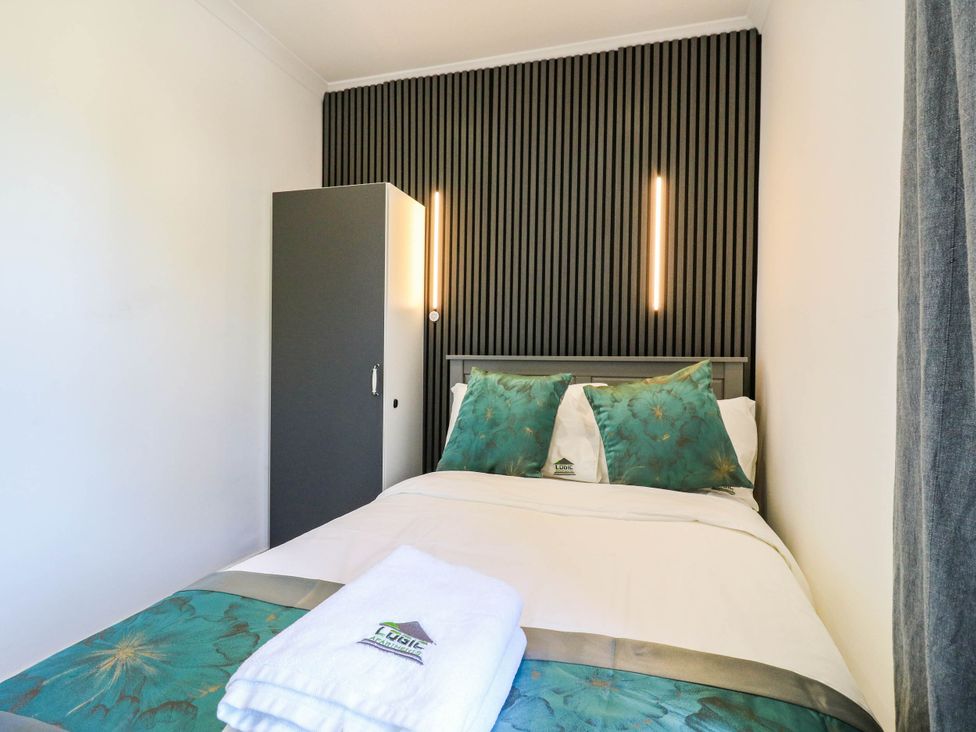 A bedroom with a bed and wardrobe at Gillingham House in Gillingham, Kent