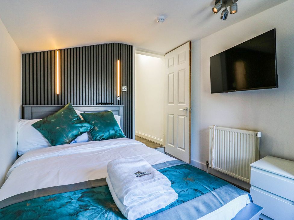 A bedroom with a bed and television at Gillingham House in Gillingham, Kent