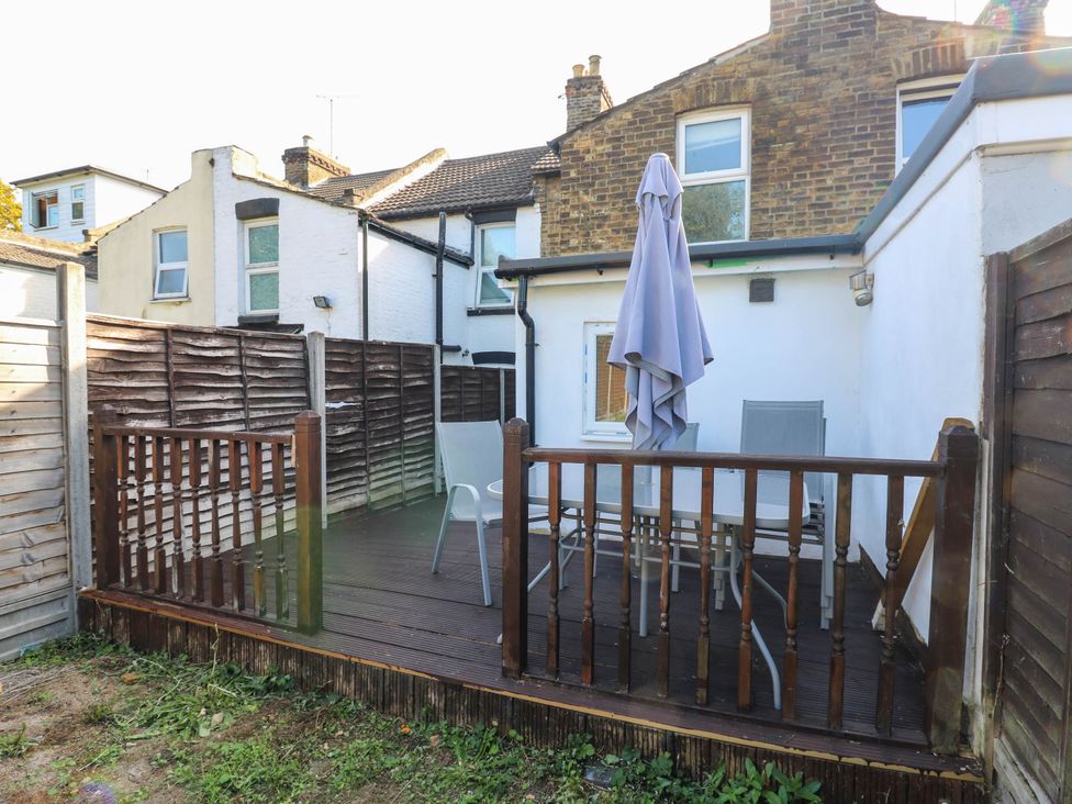 An outdoor deck with a table and chairs at Gillingham House in Gillingham, Kent