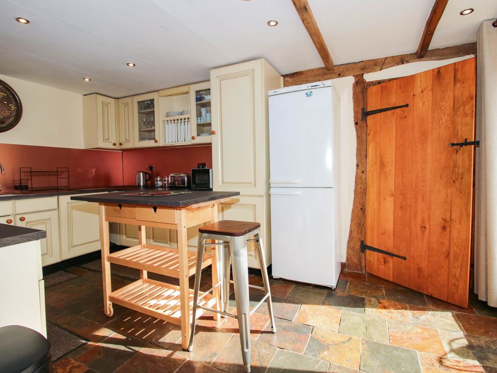 A kitchen with a refrigerator and a kitchen island at The Duck House at Hyssington Farm near Montgomery