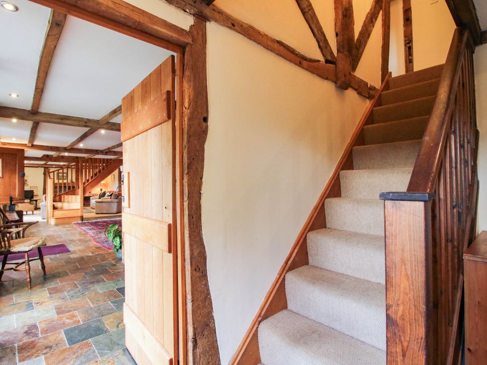 A hallway with a staircase and door at The Duck House at Hyssington Farm