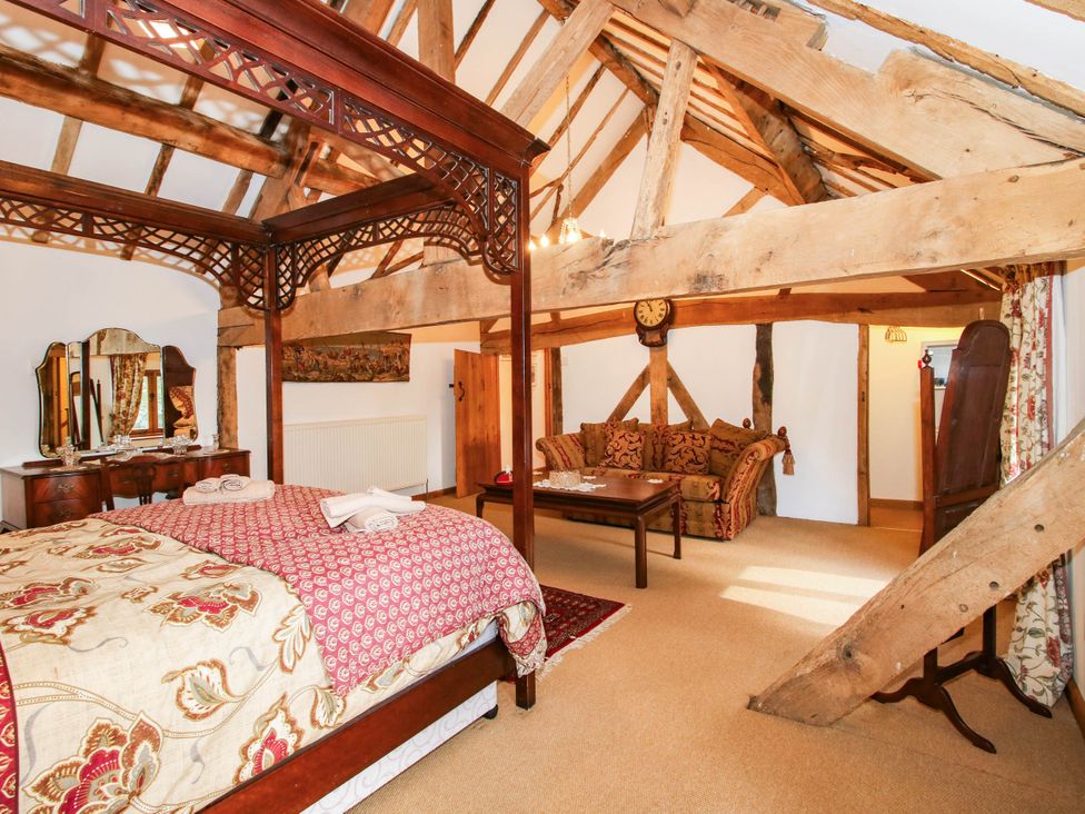 A bedroom with a four-poster bed and a sofa at The Duck House at Hyssington Farm near Montgomery