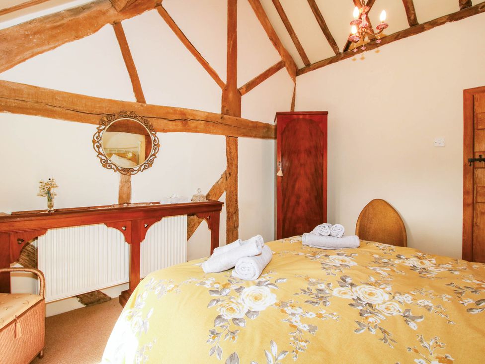 A bedroom with a yellow bedspread and towels at The Duck House at Hyssington Farm near Montgomery