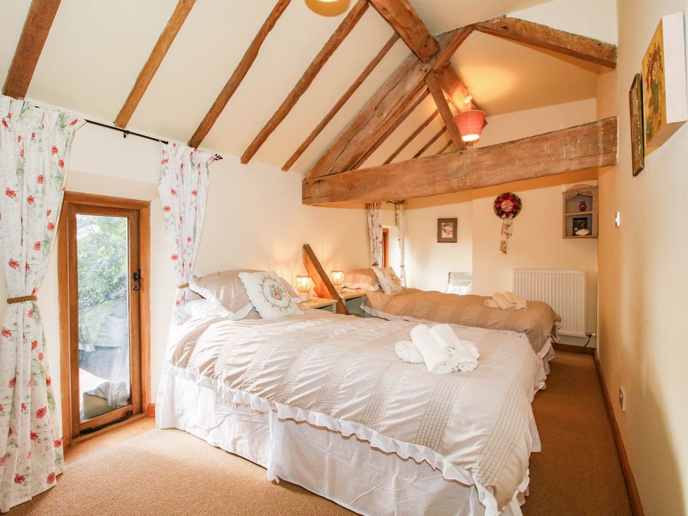 A bedroom with two beds and a window at The Duck House at Hyssington Farm near Montgomery