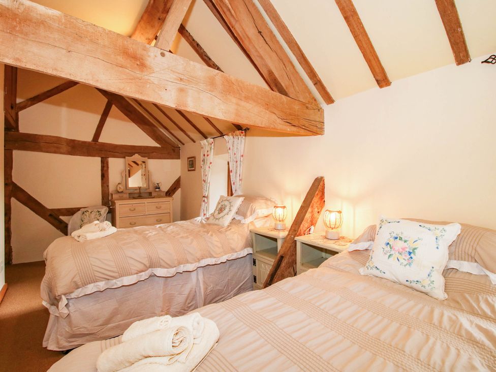 A bedroom with two beds and a dresser at The Duck House at Hyssington Farm near Montgomery