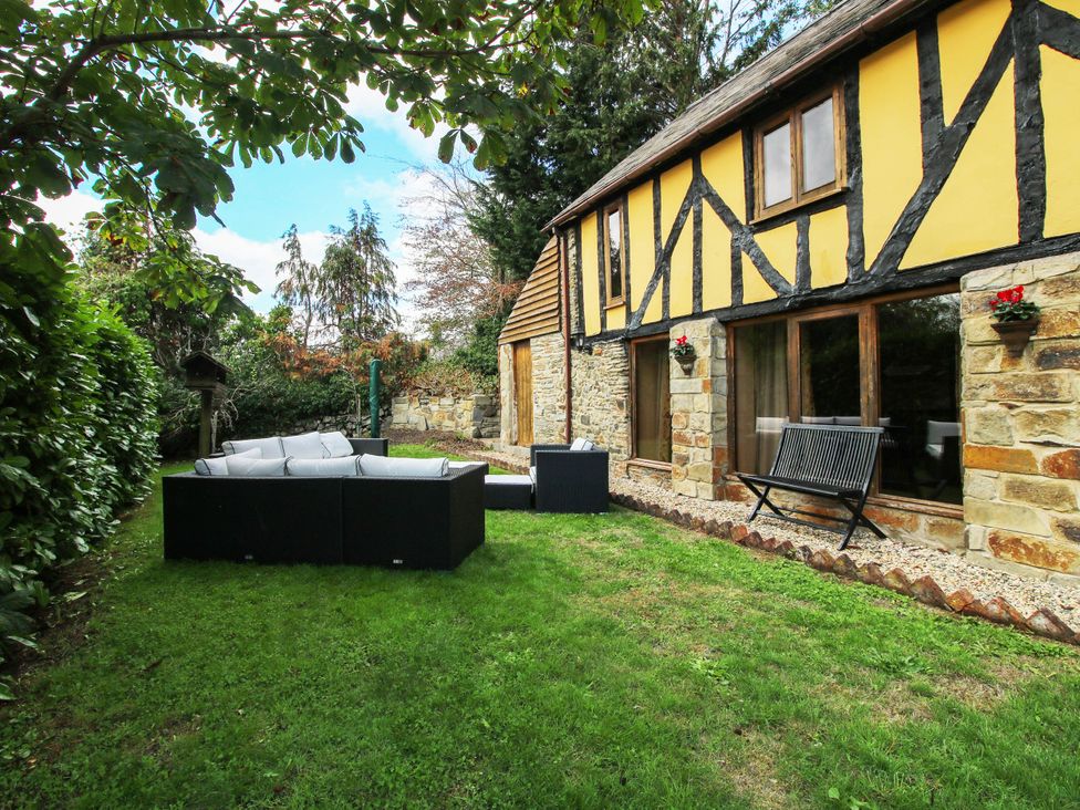A garden with a sofa set and bench at The Duck House at Hyssington Farm near Montgomery
