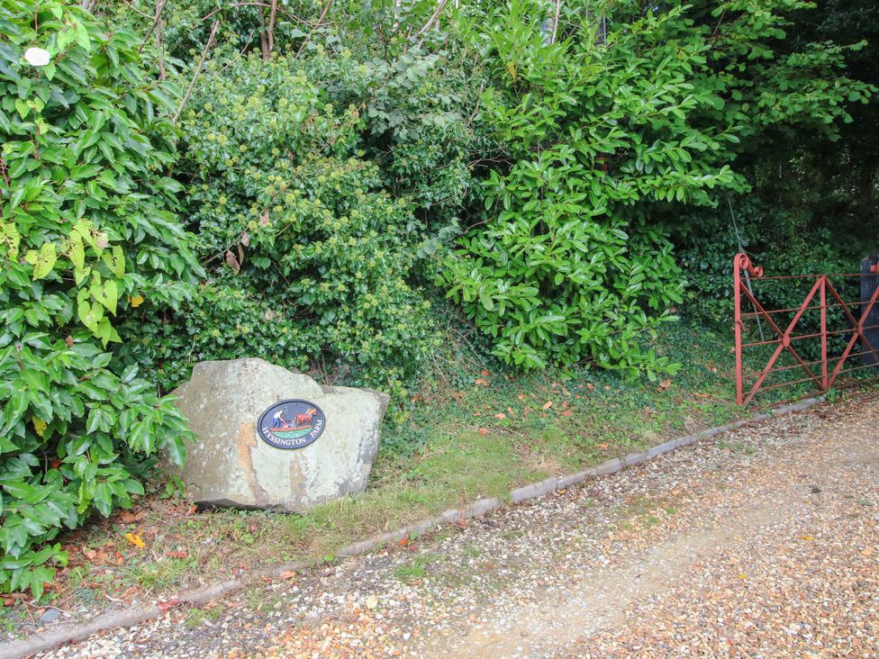 A sign and gate along a gravel path at The Duck House at Hyssington Farm near Montgomery