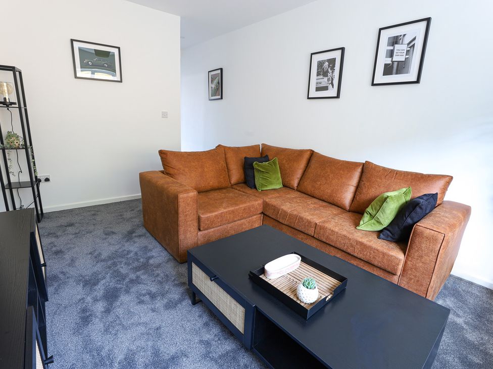 A living room with a sofa and coffee table at 5 Woodland Crescent in Manchester