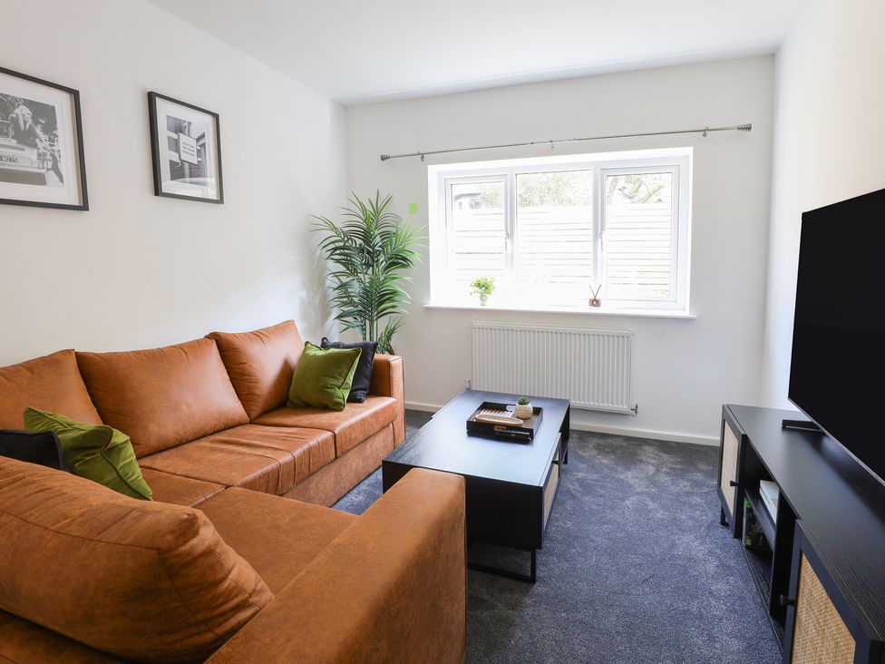 A living room with a sofa and coffee table at 5 Woodland Crescent in Manchester