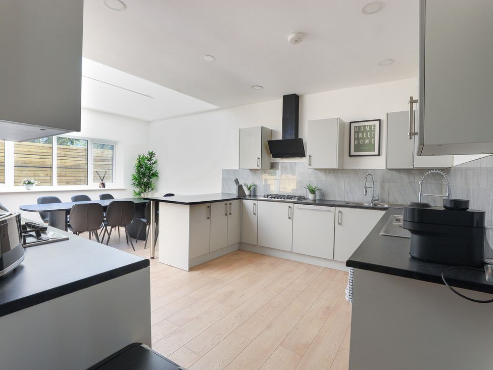 A kitchen with an island and dining table at 5 Woodland Crescent in Manchester