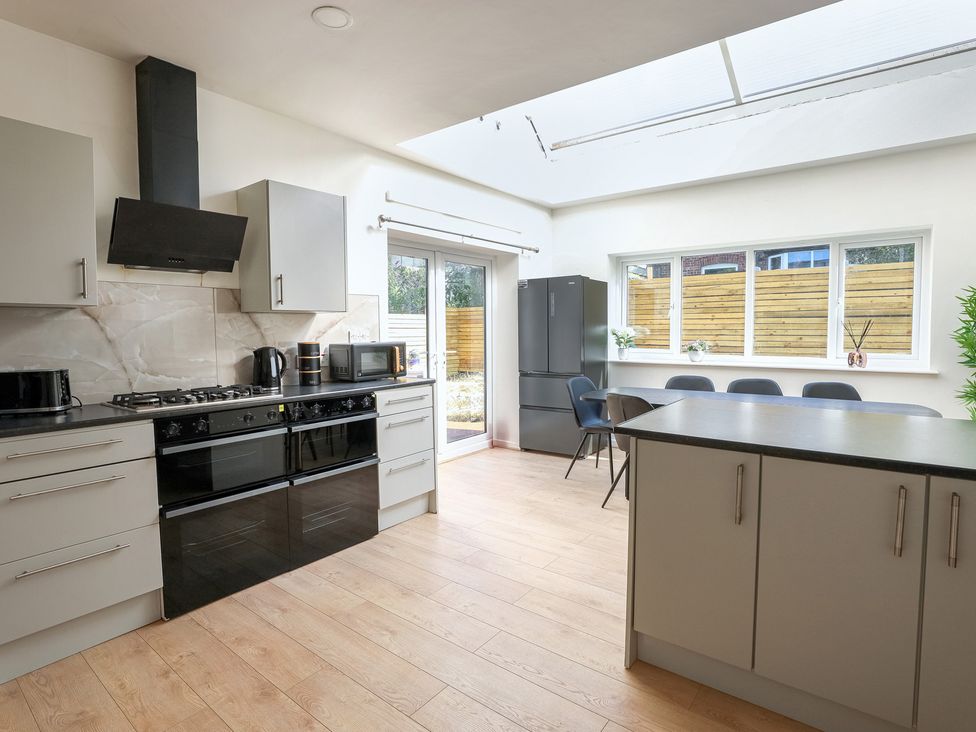 A kitchen with appliances and table at 5 Woodland Crescent in Manchester