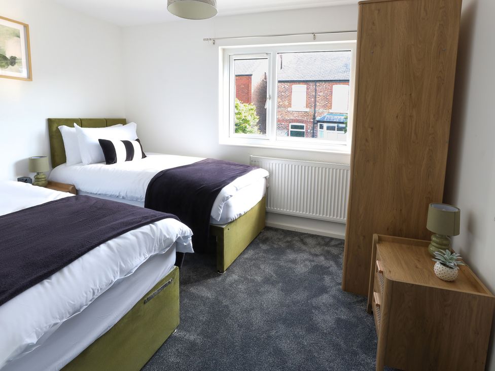A bedroom with two beds and a wardrobe at 5 Woodland Crescent in Manchester