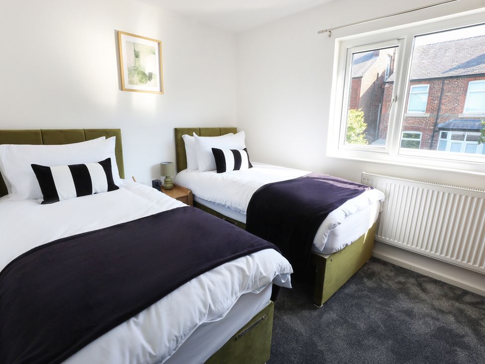 A bedroom with two beds and a window at 5 Woodland Crescent in Manchester