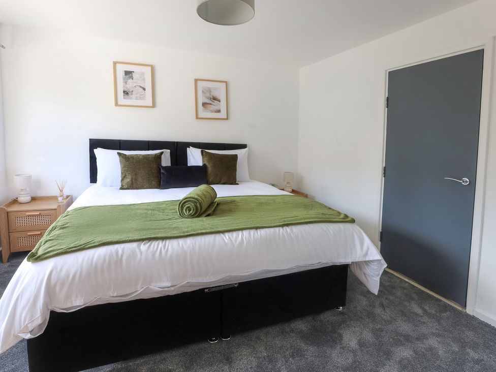 A bedroom with a bed and nightstand at 5 Woodland Crescent Manchester